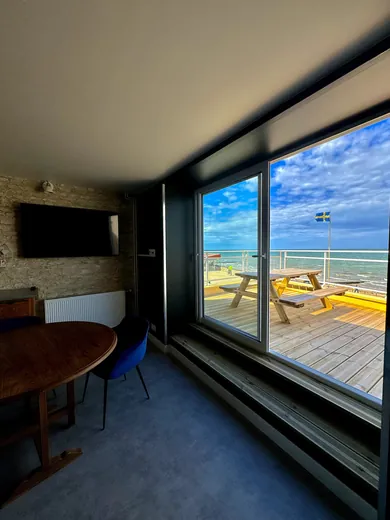 Living room with a picture window onto the terrace and the sea